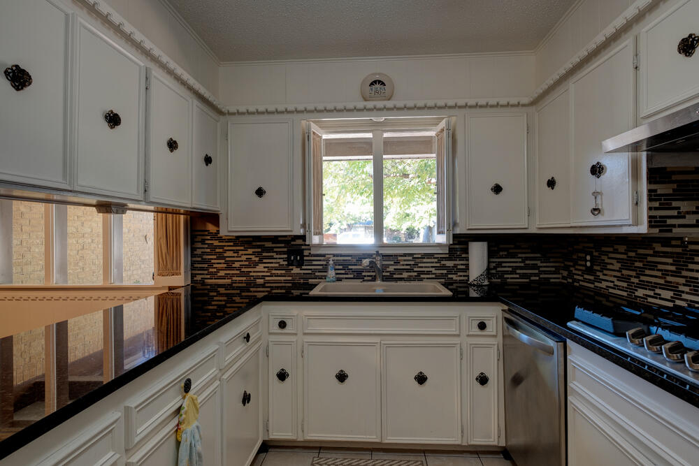 4509 62nd Street Lubbock, TX 79414 - Photo 8 of 20 a kitchen with granite countertop a stove and a refrigerator