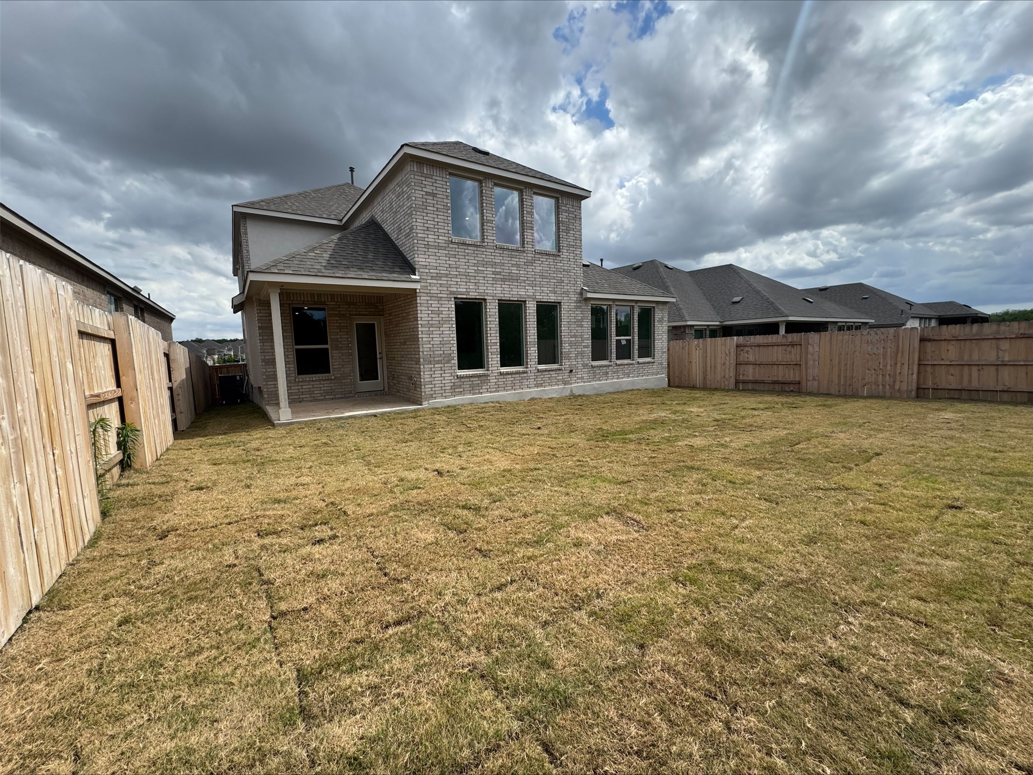 548 Tubman Drive Kyle, TX 78640 - Photo 11 of 13 a view of a yard in front of a house with large windows