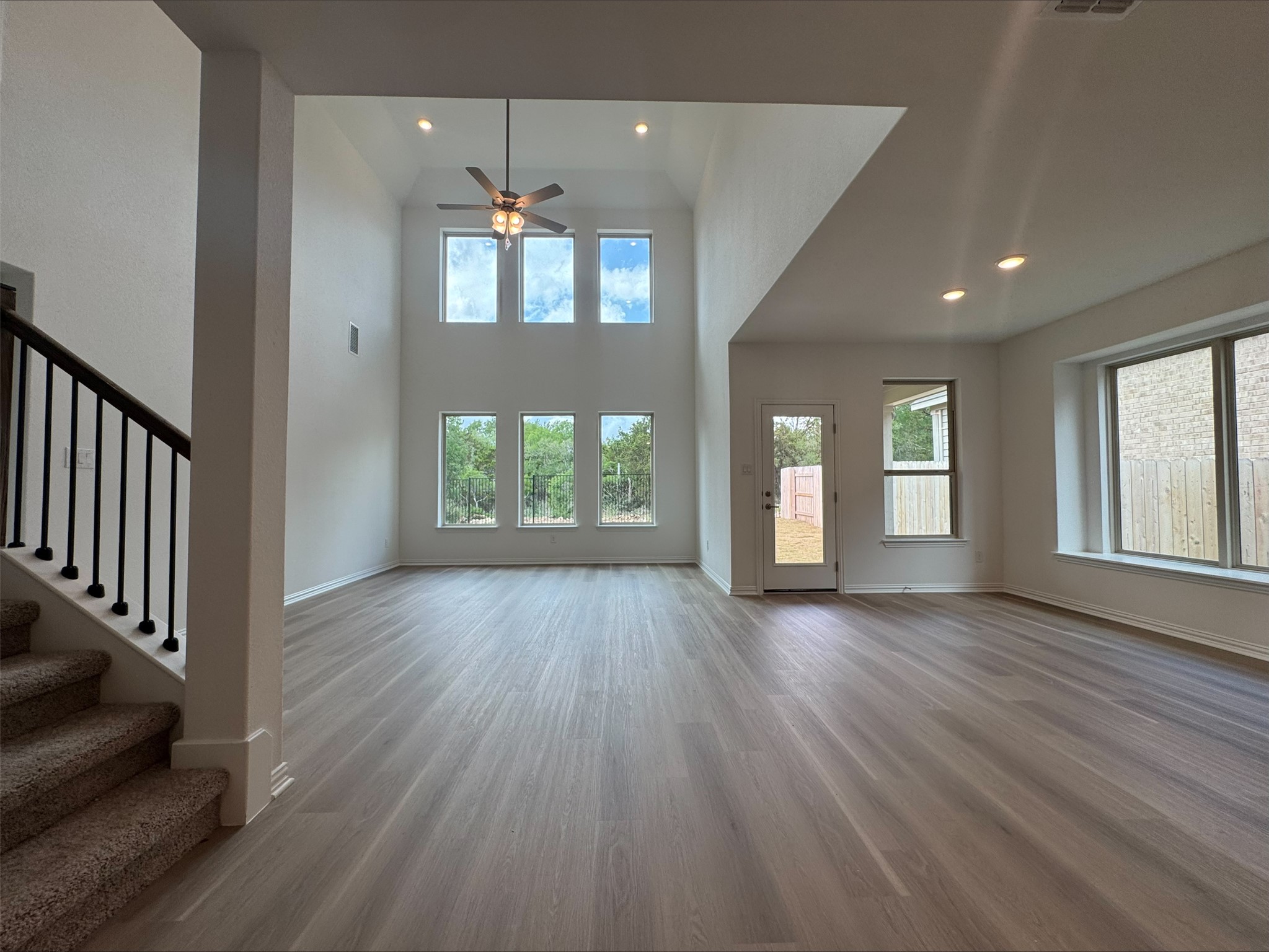 548 Tubman Drive Kyle, TX 78640 - Photo 3 of 13 an empty room with wooden floor and windows