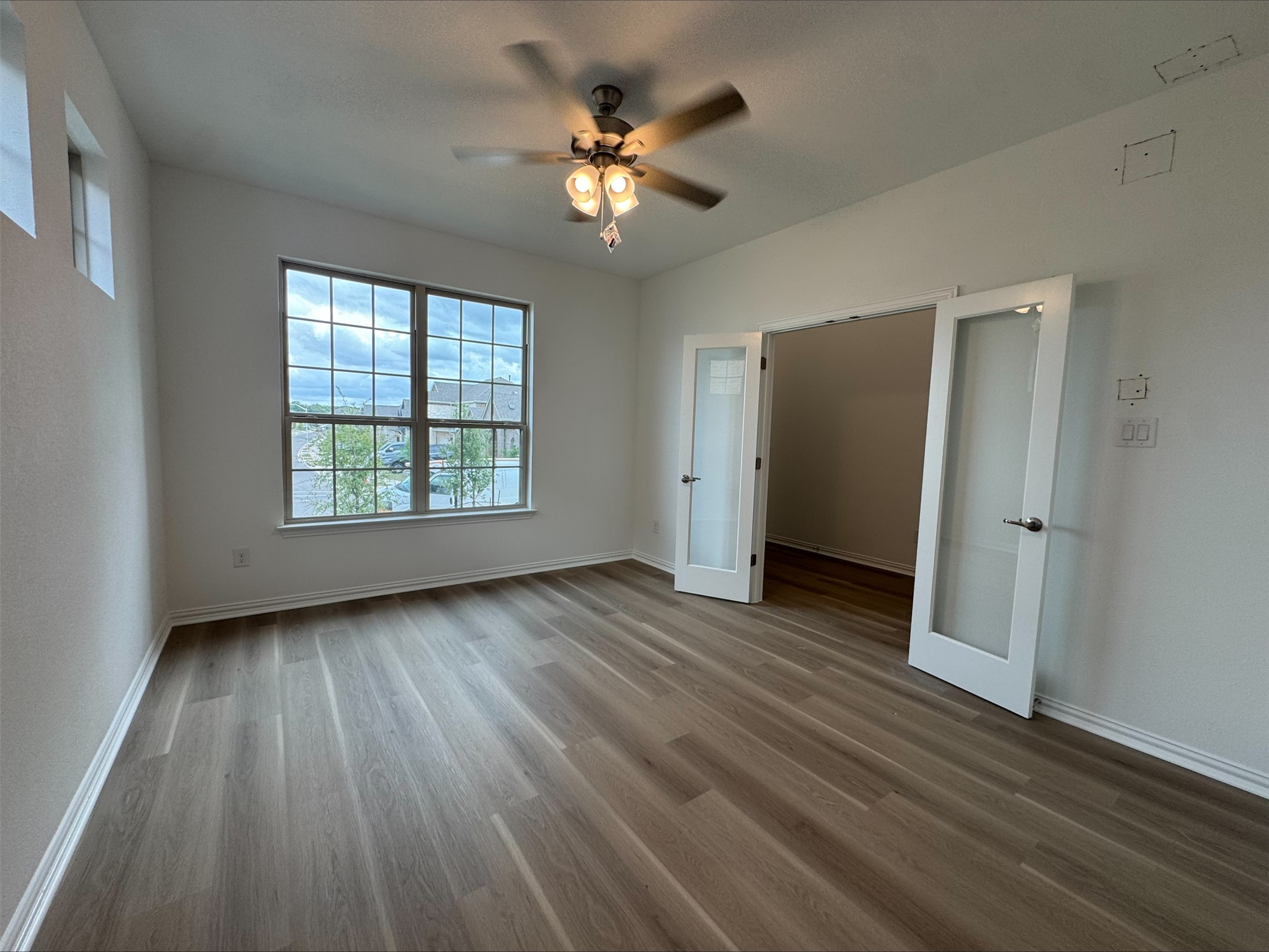 548 Tubman Drive Kyle, TX 78640 - Photo 6 of 13 an empty room with wooden floor and windows