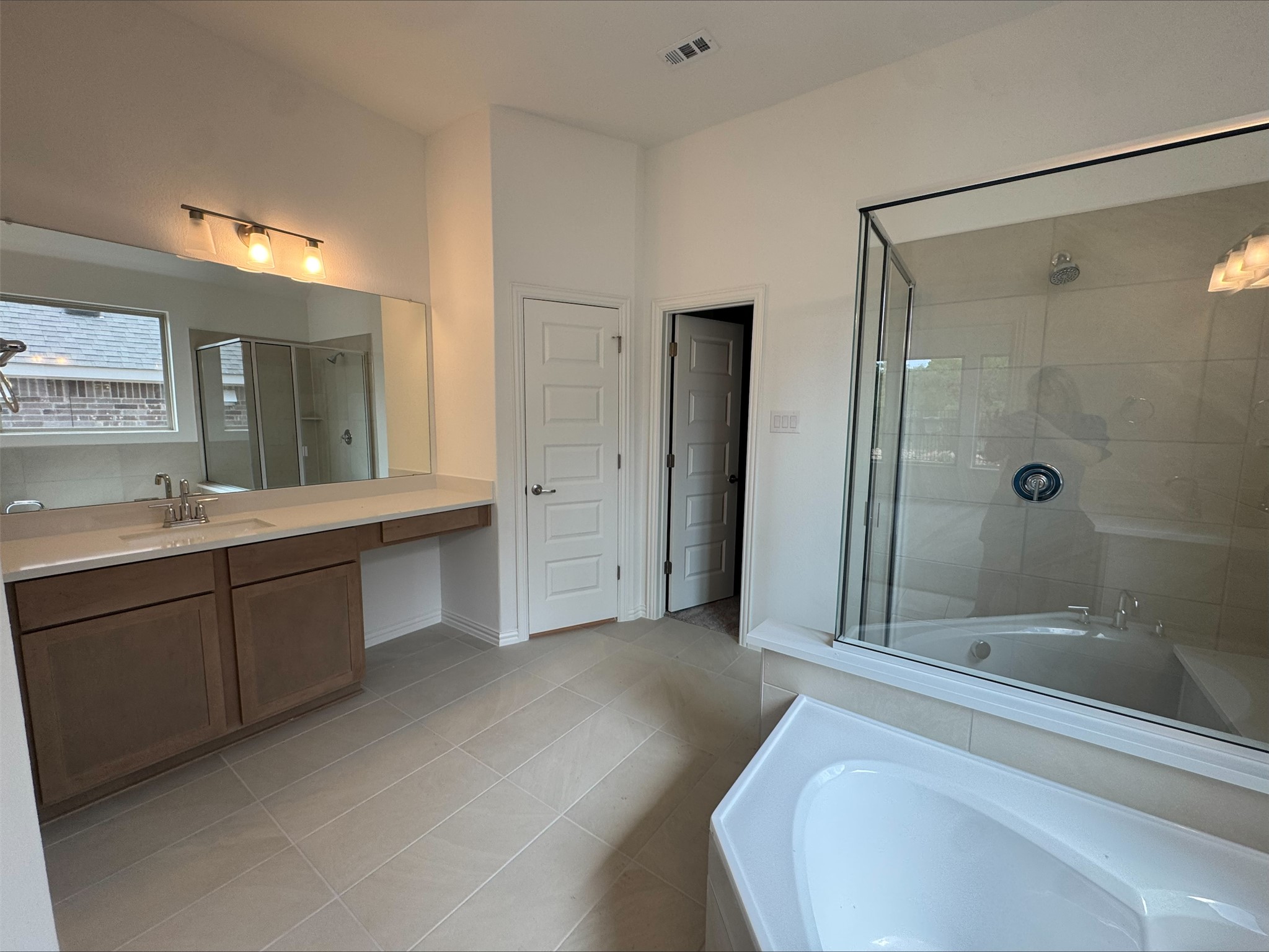 548 Tubman Drive Kyle, TX 78640 - Photo 7 of 13 a spacious bathroom with a tub shower sink and mirror