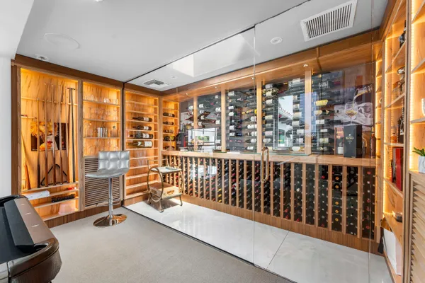 a view of a white house with a large tree and wooden fence