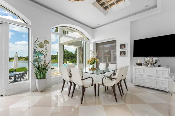 a view of a patio with table and chairs potted plants and palm tree