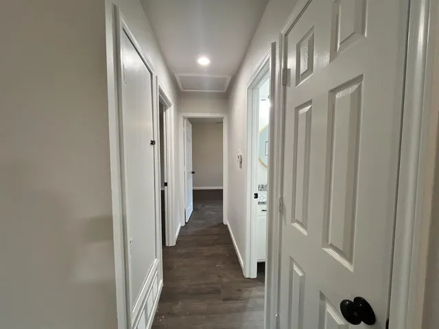 a view of a hallway with wooden floor