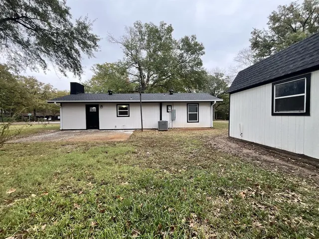 a front view of house with yard and trees around