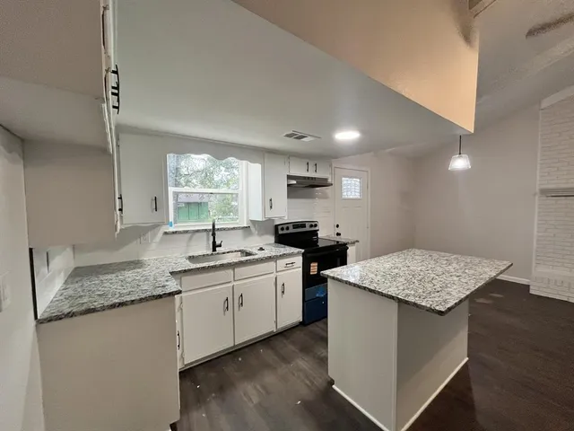 a kitchen with a sink stove and cabinets