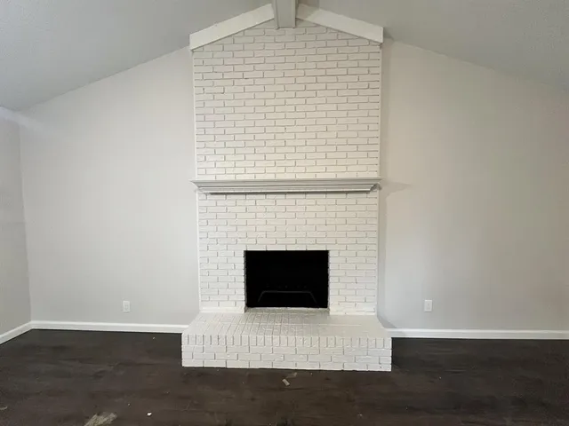 a living room with a fireplace and a wooden floor