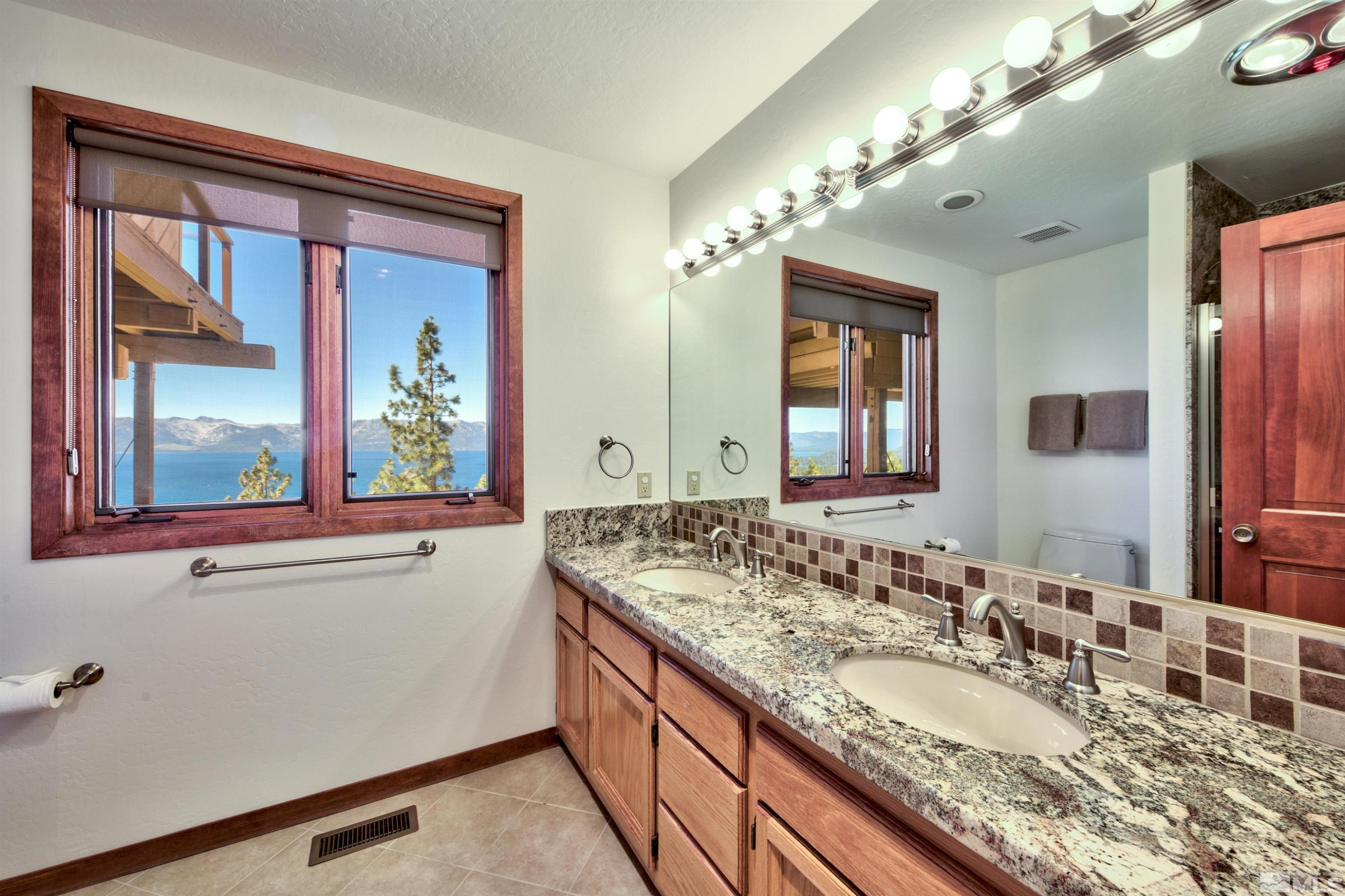 319 Pheasant Drive Glenbrook, NV 89413 - Photo 32 of 40 a bathroom with a granite countertop sink and a large mirror