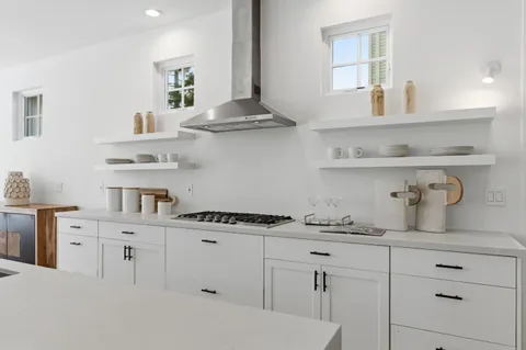 a kitchen with white cabinets and a wooden floor