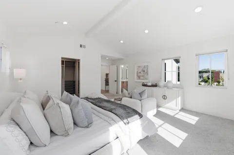 a large bedroom with a bed and a couch