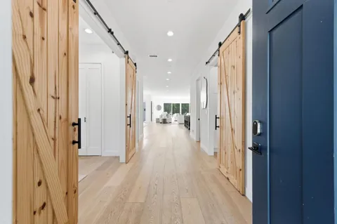 a view of a hallway with wooden floor and staircase