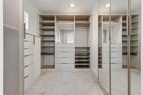 a view of walk in closet and empty room