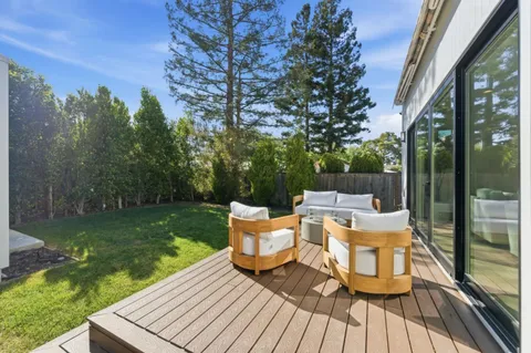 a view of a patio with table and chairs and potted plants with wooden fence