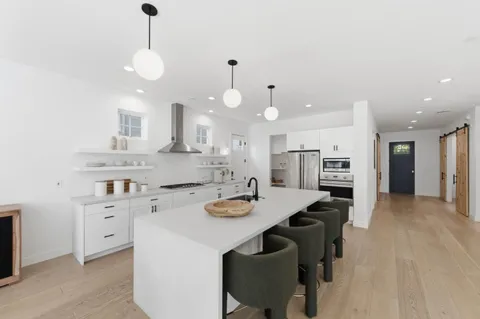 a kitchen with a dining table cabinets and appliances