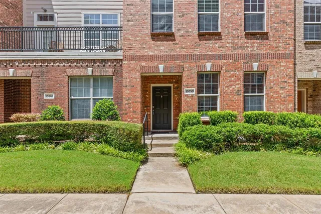 front view of a brick house with a yard