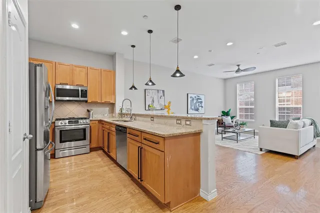 a large kitchen with stainless steel appliances kitchen island granite countertop a stove and a sink