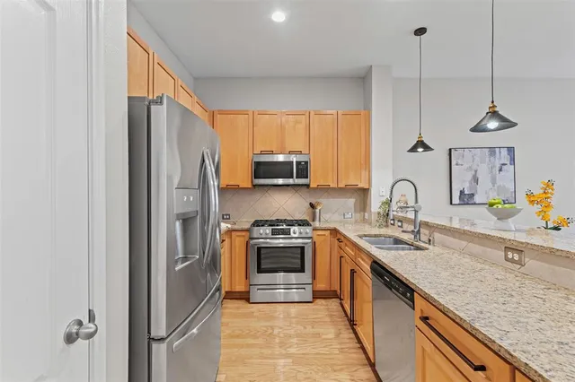 a kitchen with stainless steel appliances granite countertop a sink stove and refrigerator
