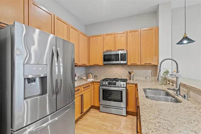 a kitchen with stainless steel appliances granite countertop a refrigerator stove and sink