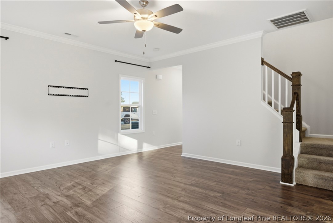 106 Knotts Berry Road Bunnlevel, NC 28323 - Photo 11 of 50 a view of an empty room with wooden floor and a ceiling fan