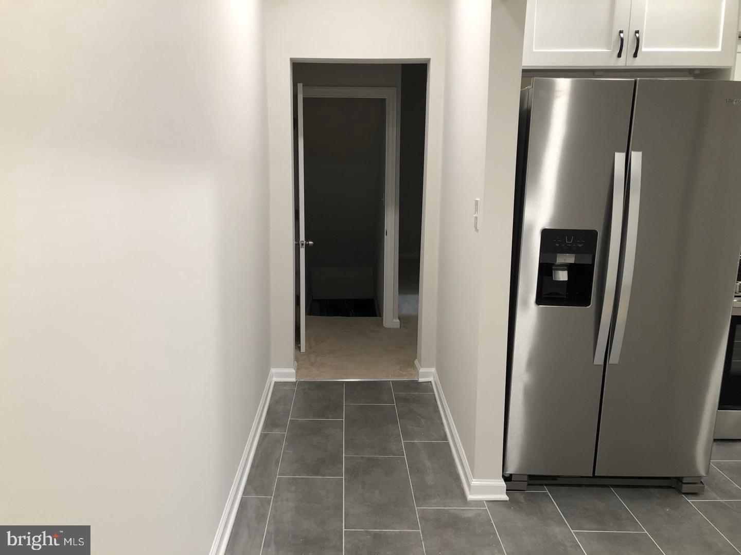 504 Bridge Street Beverly, NJ 08010 - Photo 7 of 13 a view of a refrigerator in kitchen and an empty room