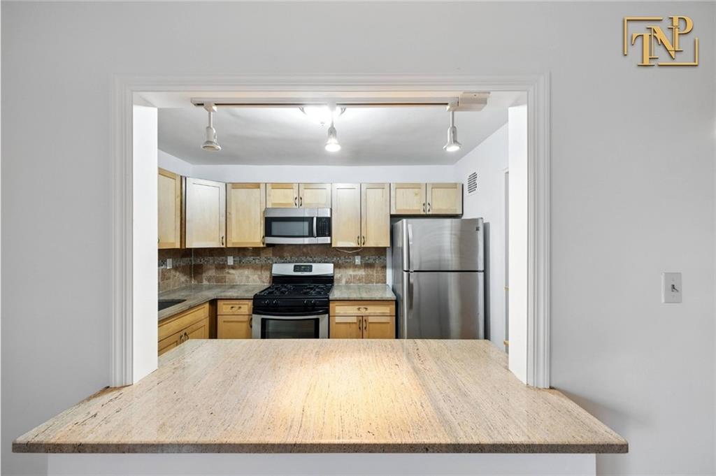 1190 East 53rd Street, Unit 5B Brooklyn, NY 11234 - Photo 6 of 15 a kitchen with stainless steel appliances granite countertop a refrigerator oven stove a sink and dishwasher
