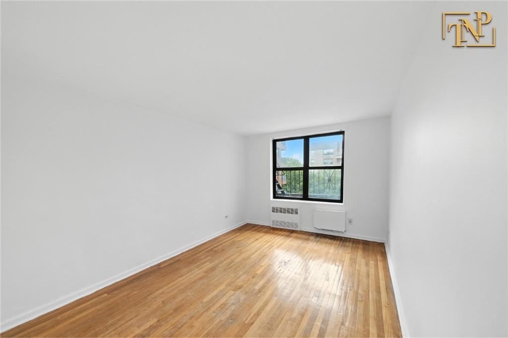 1190 East 53rd Street, Unit 5B Brooklyn, NY 11234 - Photo 9 of 15 an empty room with wooden floor and windows