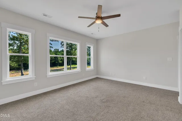 an empty room with closet and windows