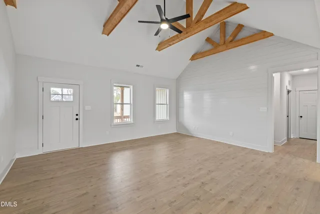 a view of a livingroom with a ceiling fan and kitchen view