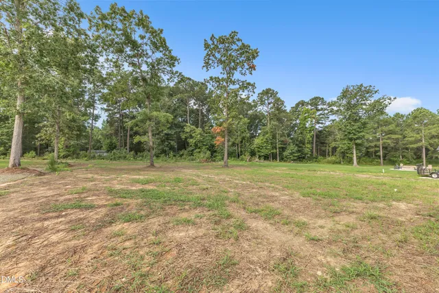 a kitchen with stainless steel appliances granite countertop a stove top oven a sink and white cabinets with wooden floor