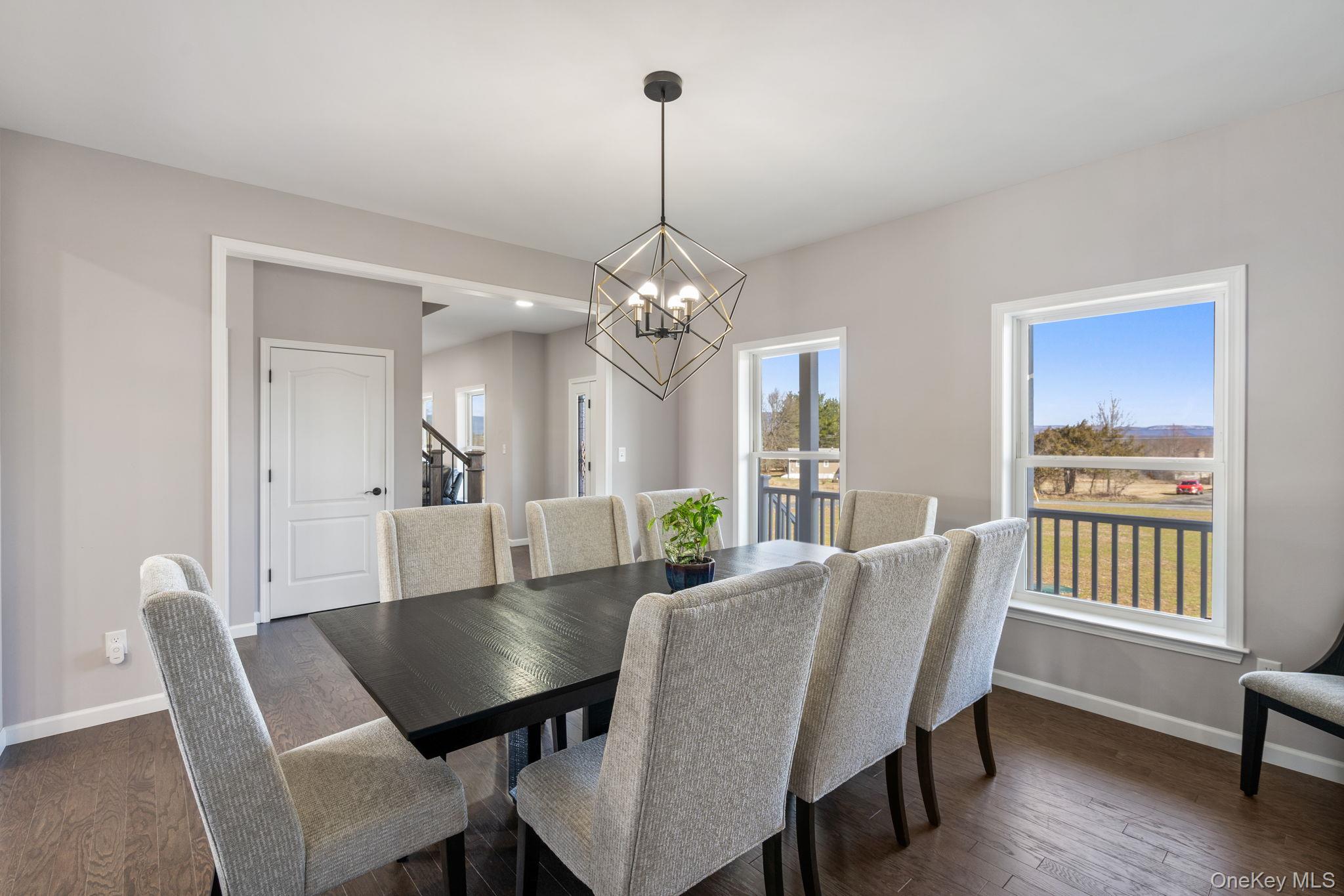 10 Harrier Ridge Drive Wallkill, NY 12589 - Photo 12 of 46 Dining space with dark wood finished floors, a chandelier, and stairs