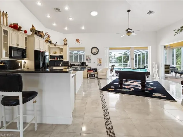 a living room with stainless steel appliances kitchen island furniture a flat screen tv and a view of kitchen
