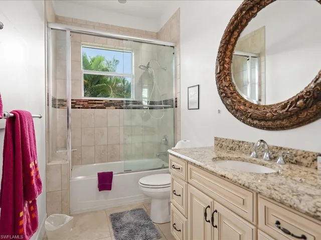 a bathroom with a granite countertop toilet a sink and a mirror