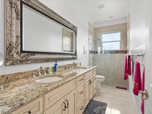 a bathroom with a granite countertop sink a large mirror and a bathtub