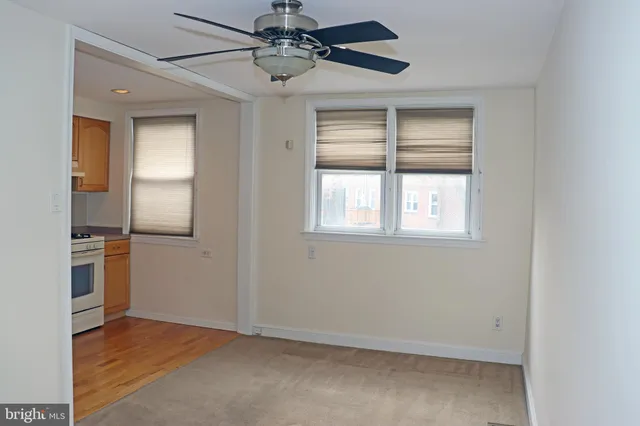 an empty room with windows and ceiling fan