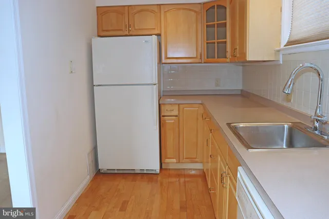 a kitchen with a refrigerator sink and cabinets