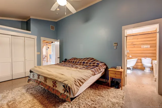 a bedroom with a bed and a dresser next to a window