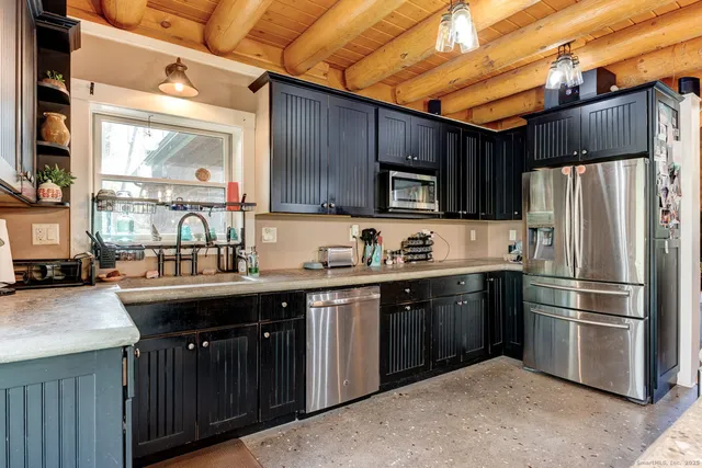 a kitchen with stainless steel appliances granite countertop a stove a sink dishwasher a refrigerator and a microwave oven with wooden cabinets