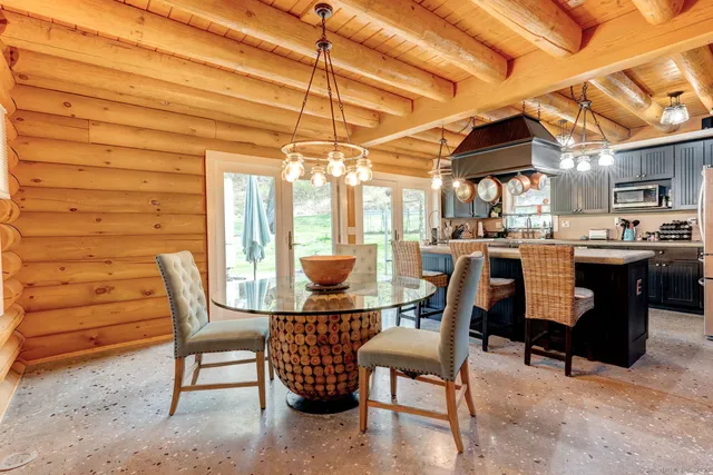 a dining room with a wooden table and chairs