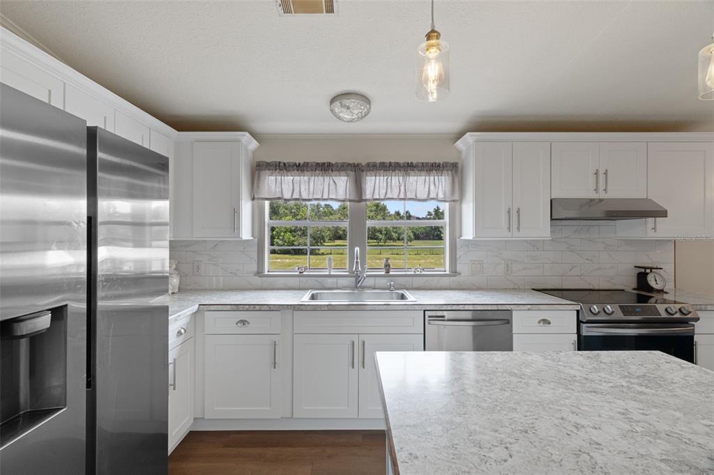26255 Lambeth Road Brooksville, FL 34601 - Photo 19 of 76 a kitchen with stainless steel appliances granite countertop a stove and a sink