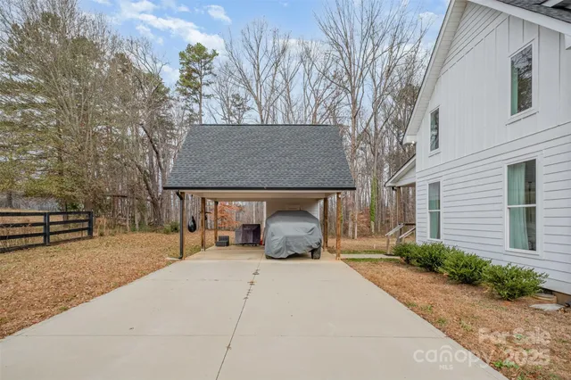 a front view of a house with outdoor seating and covered with trees