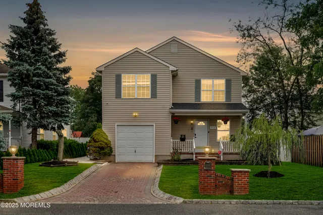 a front view of a house with yard and green space