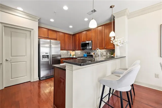 a kitchen with granite countertop wooden cabinets and a refrigerator