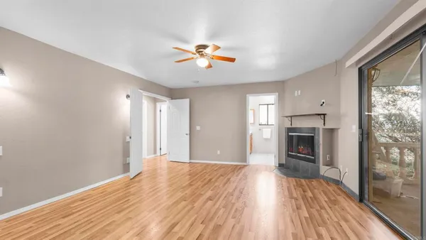 a view of empty room with wooden floor and fireplace