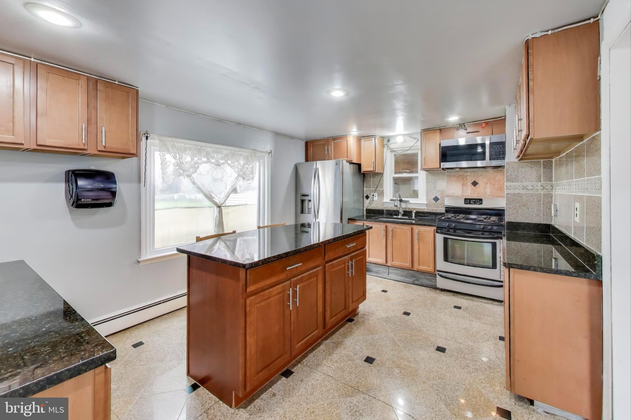 9211 Fowler Lane Lanham, MD 20706 - Photo 14 of 50 a kitchen with stainless steel appliances granite countertop a stove a sink and a refrigerator