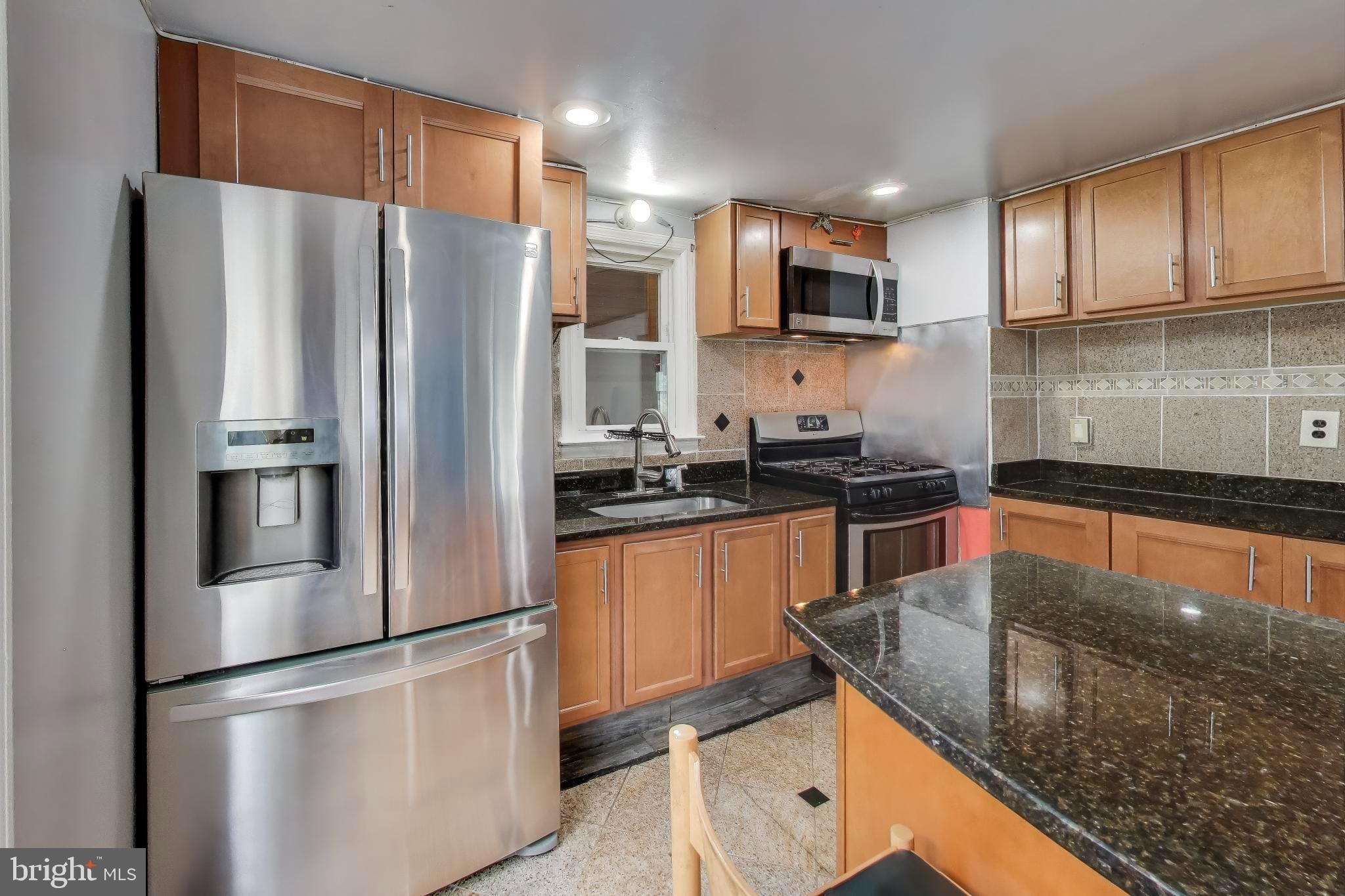 9211 Fowler Lane Lanham, MD 20706 - Photo 15 of 50 a kitchen with stainless steel appliances granite countertop a refrigerator a stove top oven a sink and dishwasher