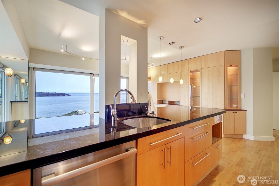 1415 2nd Avenue, Unit 1209 Seattle, WA 98101 - Photo 12 of 21 a kitchen with granite countertop a sink and a wooden floor