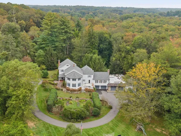 an aerial view of residential houses with outdoor space and trees