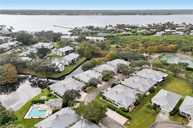 an aerial view of a house with swimming pool and large trees