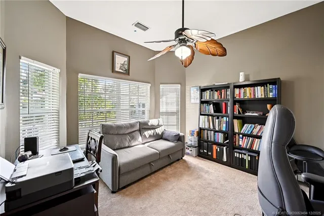 a living room with furniture a bookshelf and a window