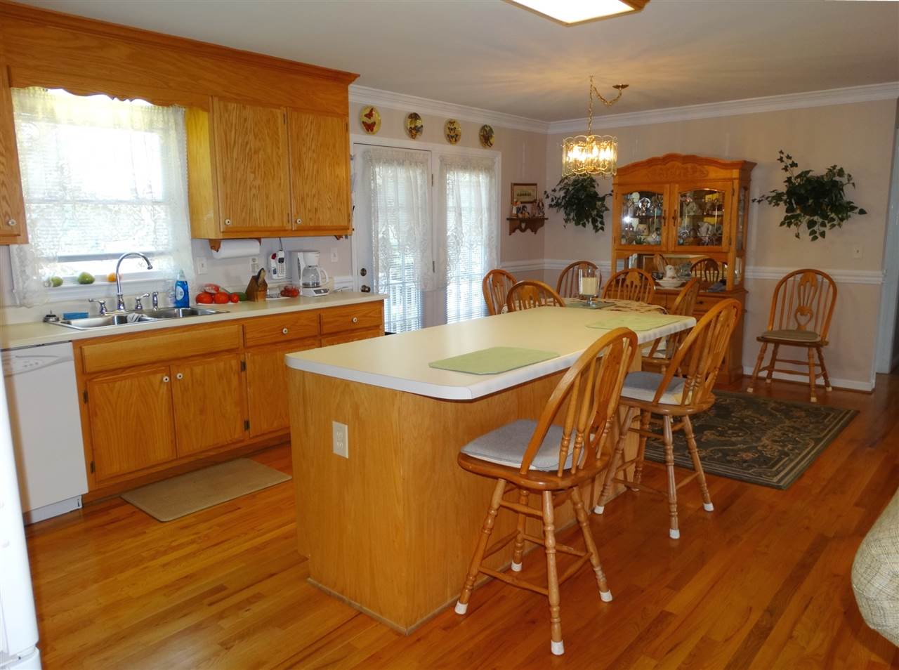 324 Good Hope Church Road Aroda, VA 22709 - Photo 17 of 32 a kitchen with stainless steel appliances granite countertop a refrigerator a stove a sink with island chairs and wooden floor